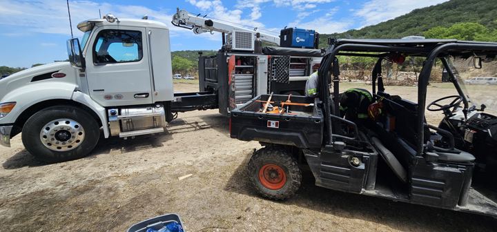Service truck and utility vehicle staged at a deployment site