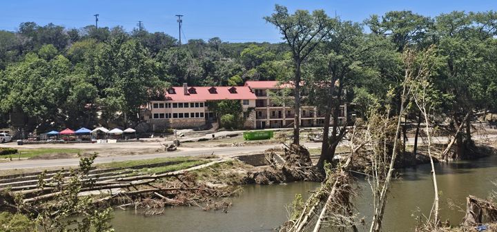 Flood debris piled below a riverside lodge