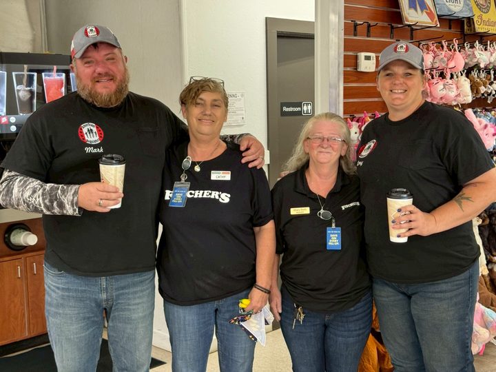 Two volunteers with staff members inside a local store during a community visit