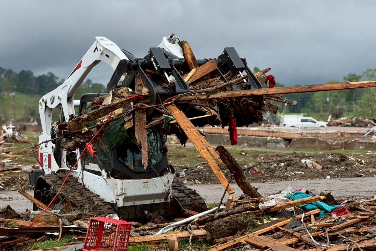 A skid steer lifts tornado debris after the London, Kentucky EF4 tornado