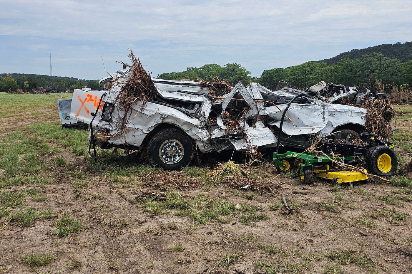 A crushed truck left in a field by floodwater