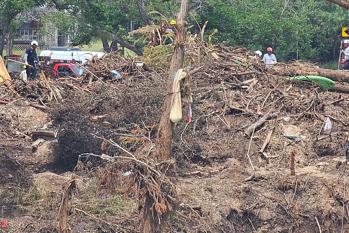 Volunteers working through a tangle of flood debris