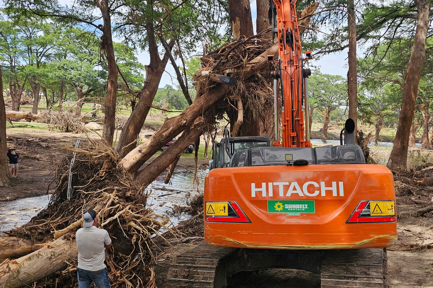 Excavator clearing debris along a river